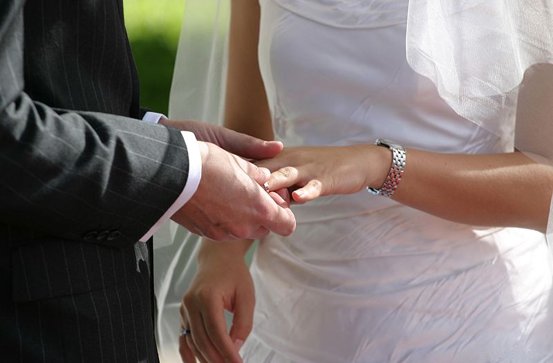 גבר עונד טבעת לאישה בחתונה